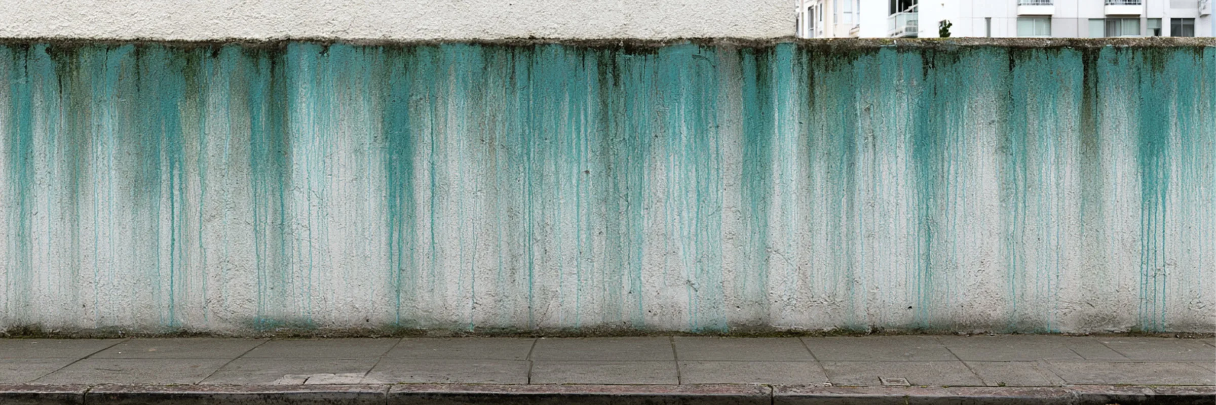 A weathered exterior wall with visible water seepage staining